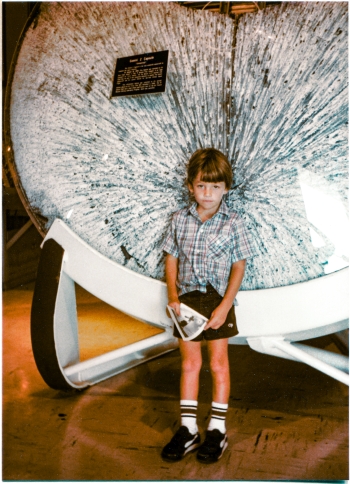 Kai at the Air Force Space and Missile Museum, Cape Canaveral Air Force Station, Florida. Behind him, the heat shield of the Gemini 2 capsule showing the effects of the hellish heat of re-entry which must be safely endured, to bring a thing, to bring people, back from orbit around the Earth. Photograph by James MacLaren.
